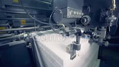 一台机器将许多纸张分开，合上。 纸张生产过程。